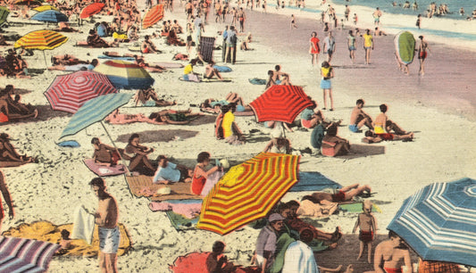 a vintage image of a beach scene. there are a lot of colorful umbrellas and a lot of people in swimwear. men swim shorts and women in bikini's and bathing suits or one-piece swimwear